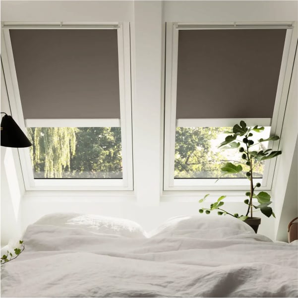 Foto di due finestre Velux con tende a rullo.