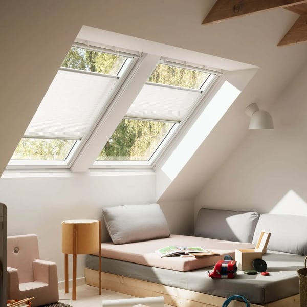 Foto di due finestre Velux con tende plissettate.